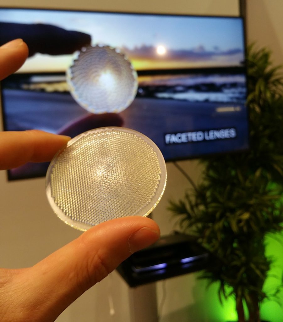 Image of handheld printed optic by Luximprint demonstrating faceted lens technology